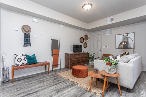 A living room with a white couch, a wooden coffee table, and a rug on the floor.