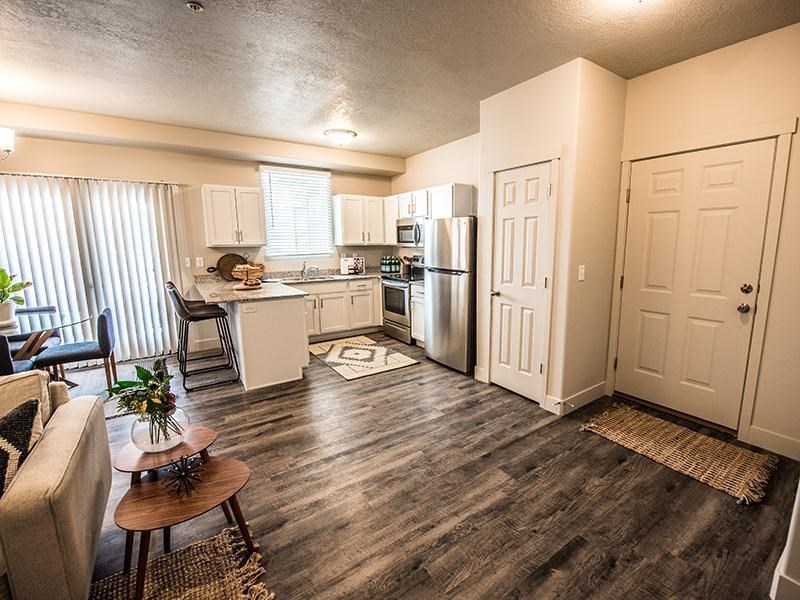 A kitchen with a refrigerator, sink, and cabinets.