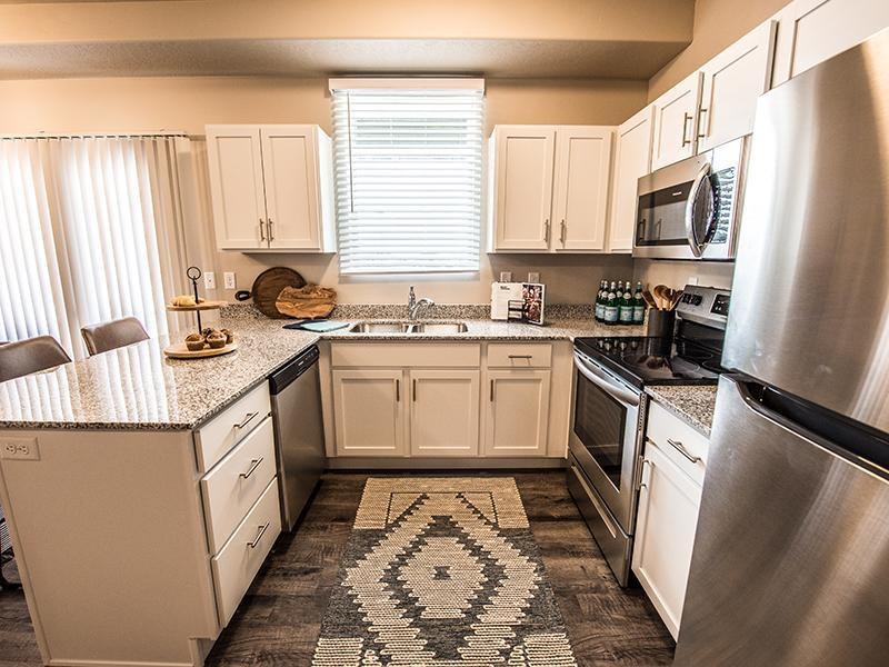 A kitchen with a black and white patterned rug on the floor.