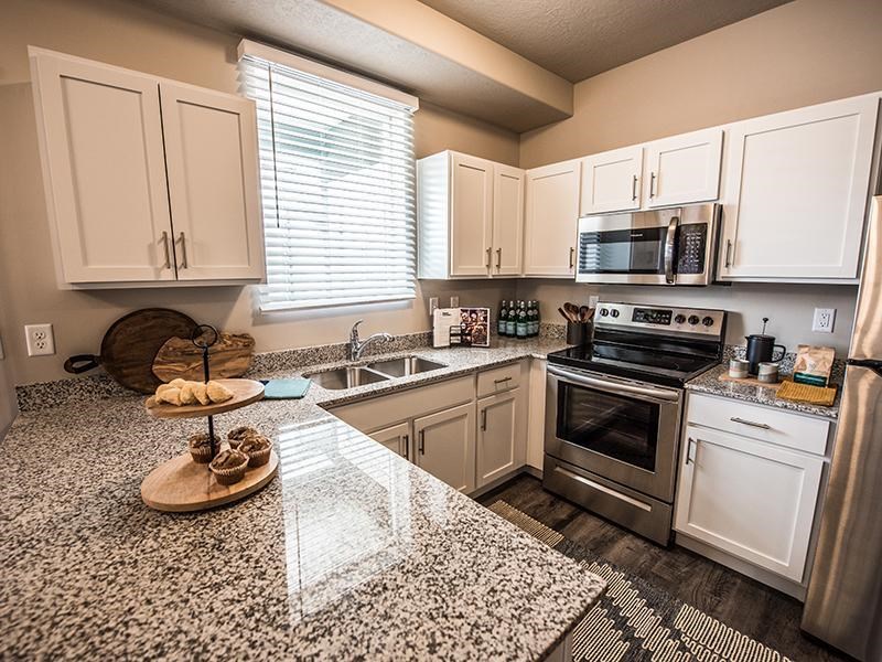 A kitchen with granite countertops and stainless steel appliances.