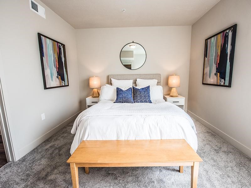 A bedroom with a white bed and a wooden coffee table.
