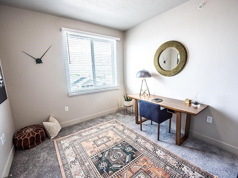 A room with a rug on the floor and a clock on the wall.