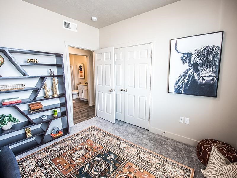 A room with a rug on the floor and a painting of a bull on the wall.