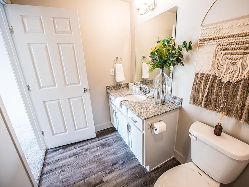 A bathroom with a toilet, sink, and mirror.