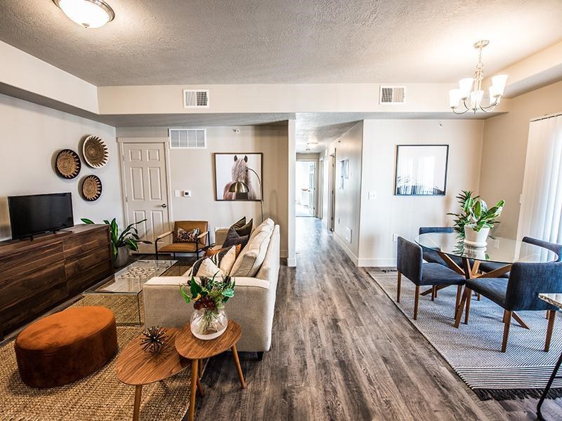 A living room with a brown wooden floor and furniture.