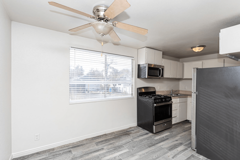 A kitchen with a black refrigerator, stove, and oven.