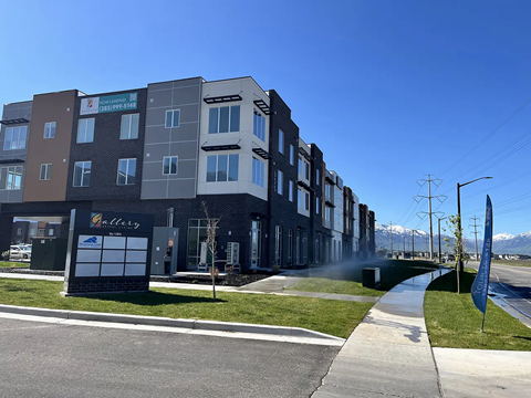 A row of modern apartment buildings with a clear blue sky above.