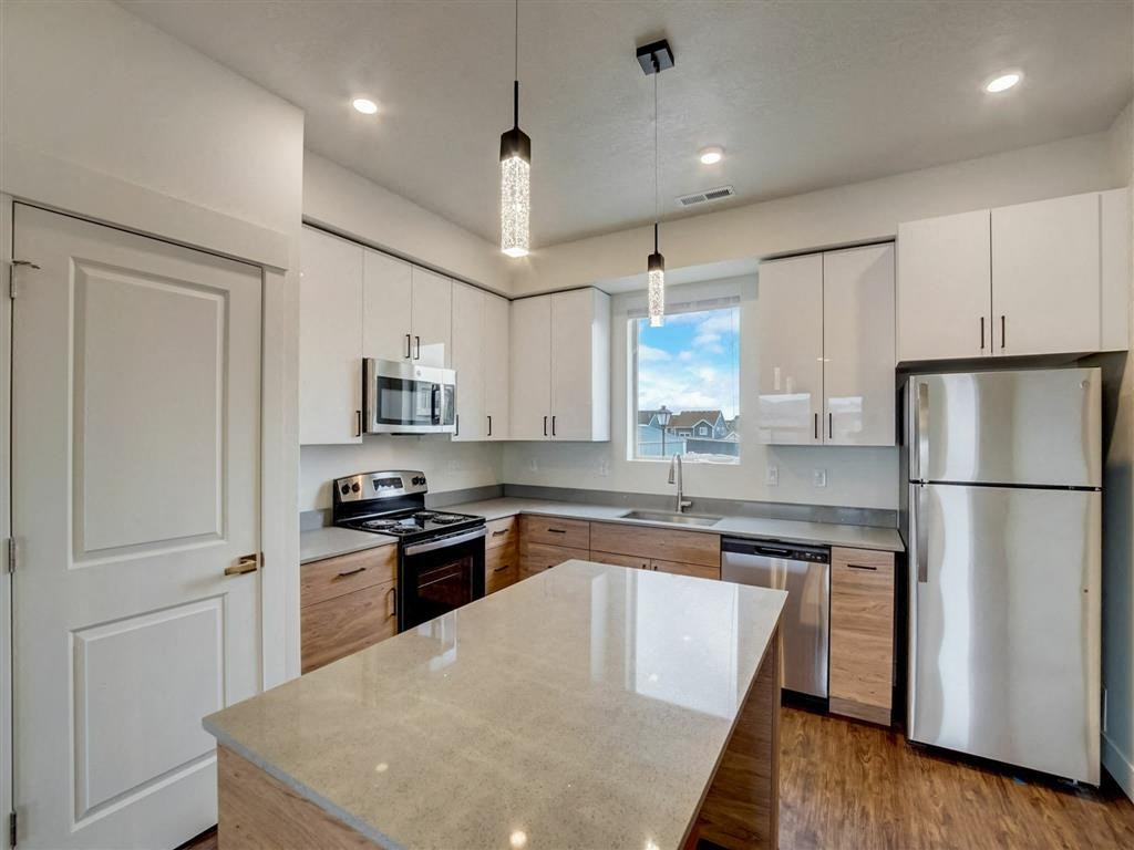 an updated kitchen with stainless steel appliances and white cabinets
