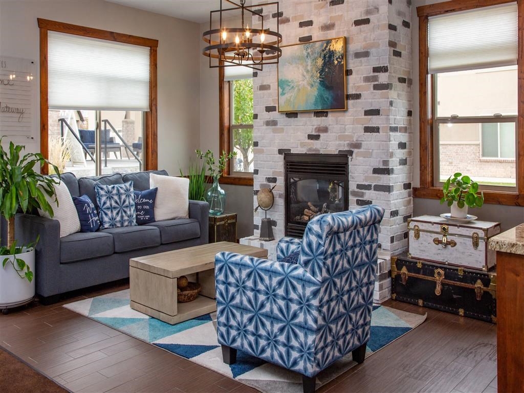 a living room with blue and white furniture and a stone fireplace