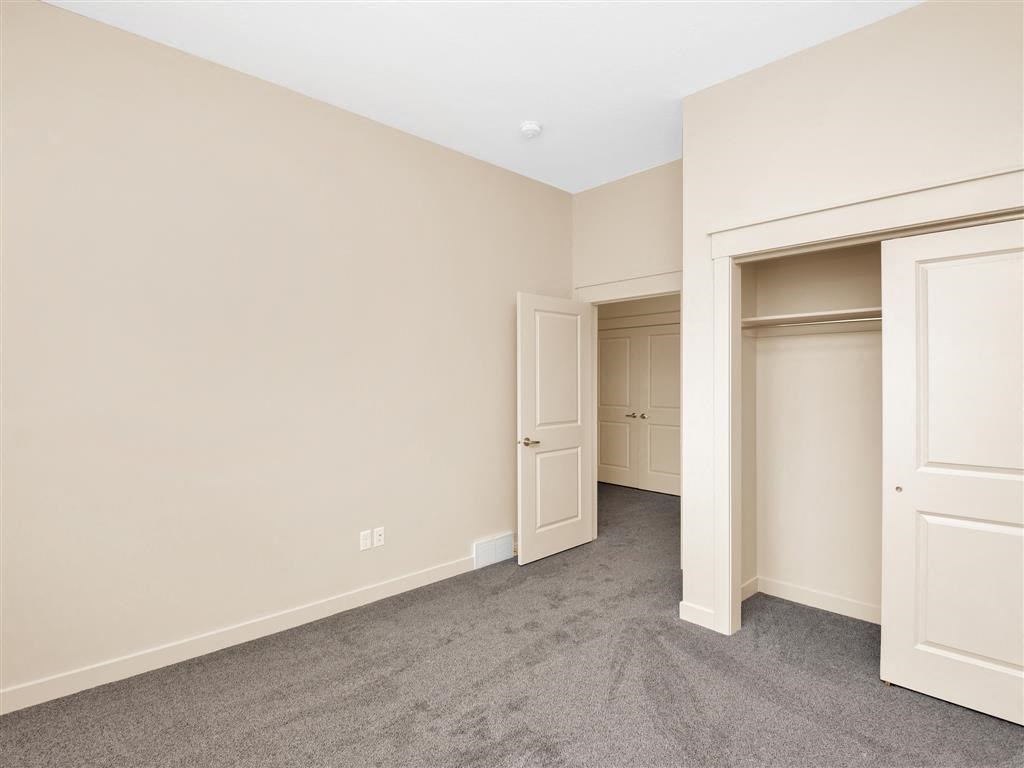 a bedroom with a closet and a door to a hallway