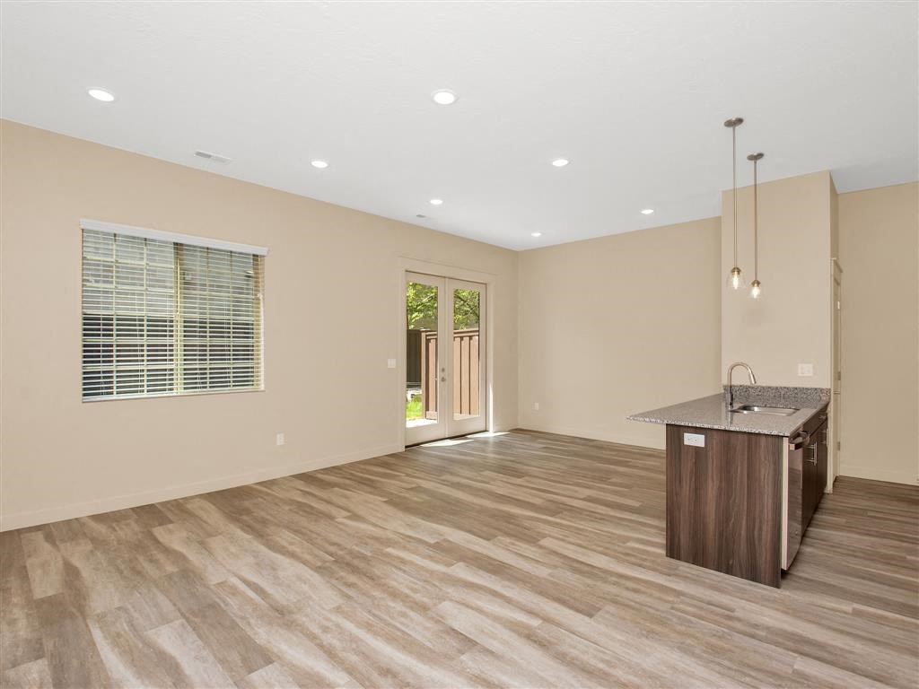 an empty living room and kitchen with a counter top
