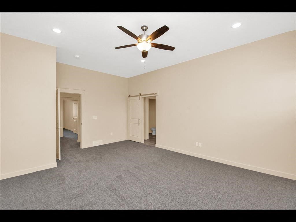 an empty living room with a ceiling fan