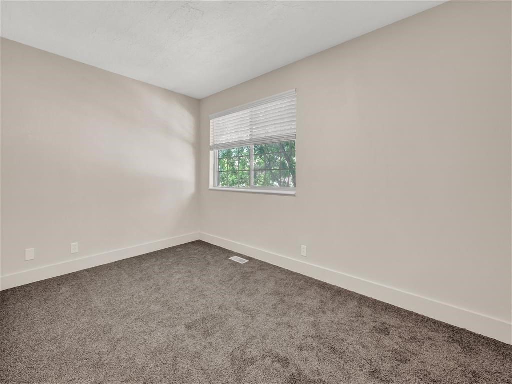 an empty room with carpet and a window
