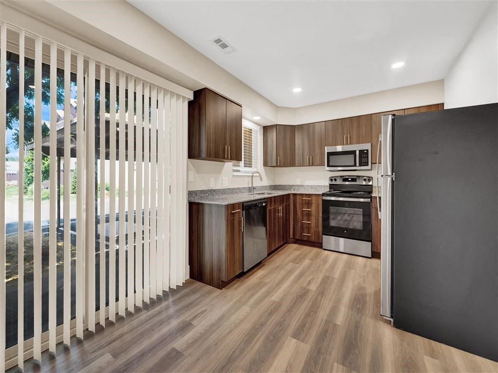a kitchen with wood floors and a sliding glass door