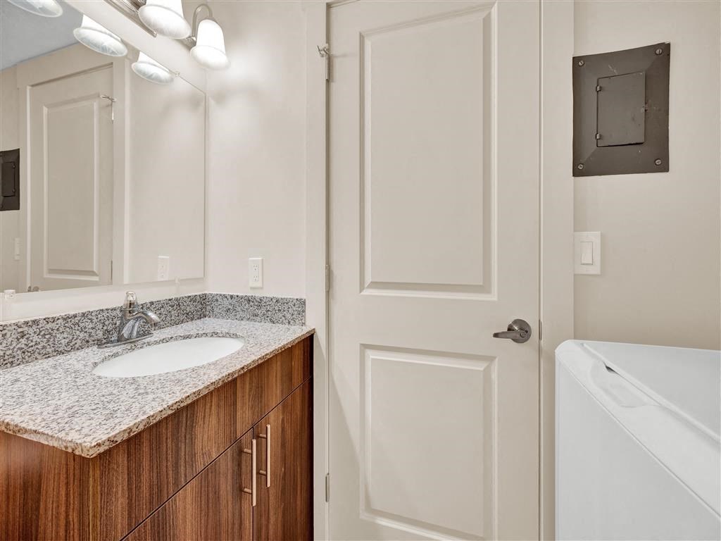 a bathroom with a sink and a mirror and a door