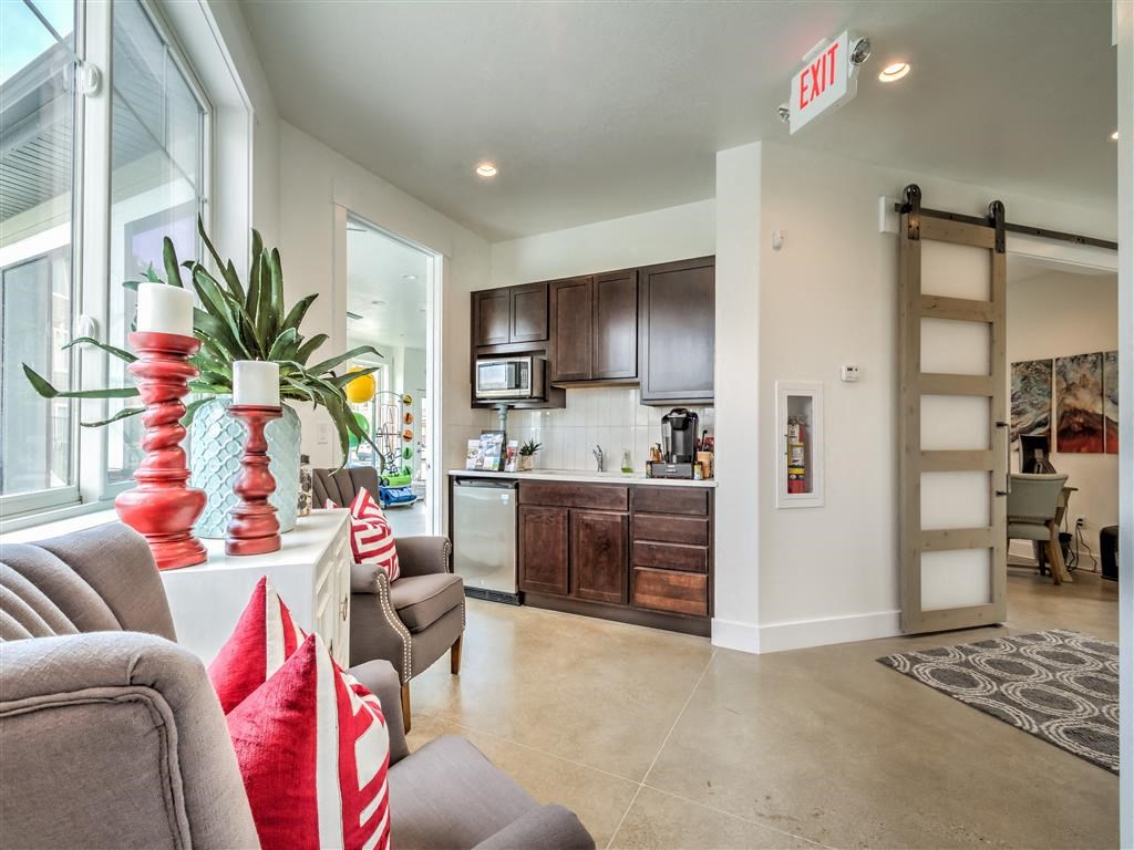 a spacious living room with a couch and a kitchen at Aderra apartments for rent in Roy, Utah