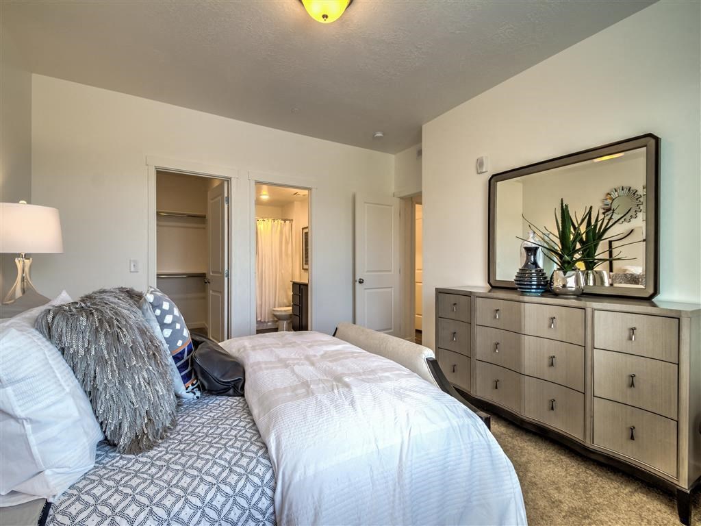 a bedroom with a bed and a yellow wall at Aderra apartments in Roy, Ut