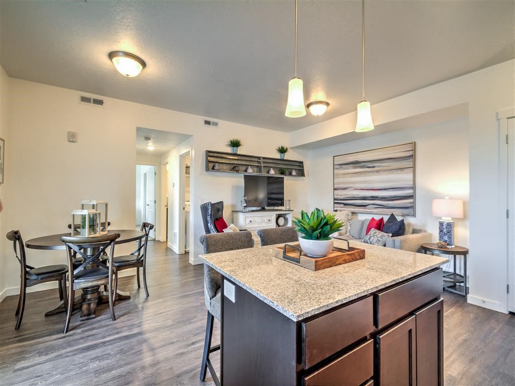 a kitchen and living room with a table and chairs at Aderra apartment complex in Roy, Utah