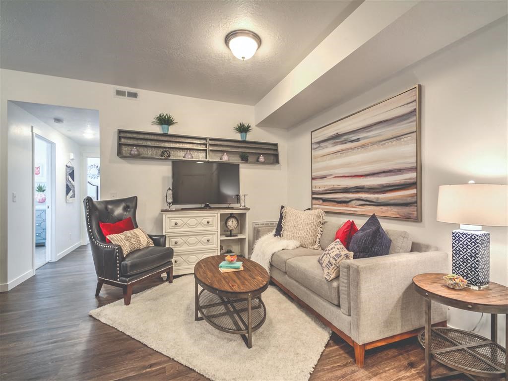 a living room with a couch and a tv at Aderra apartment complex in Roy, Utah