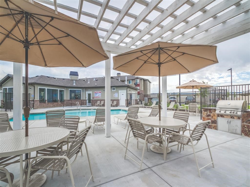 a large patio with tables and chairs and a swimming pool