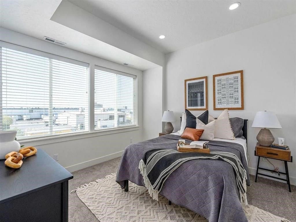 a bedroom with a bed and two windows