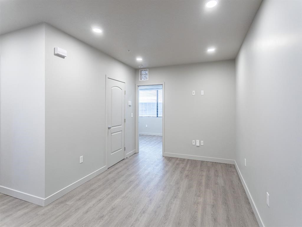 an empty living room with white walls and a door