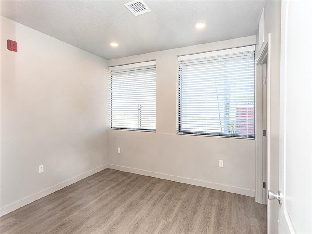 an empty room with two windows and a door