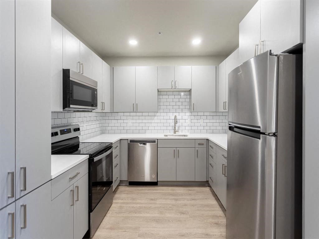 a kitchen with white cabinets and stainless steel appliances