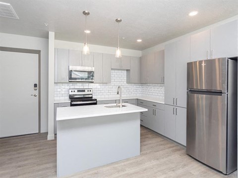 an all white kitchen with stainless steel appliances and white cabinets