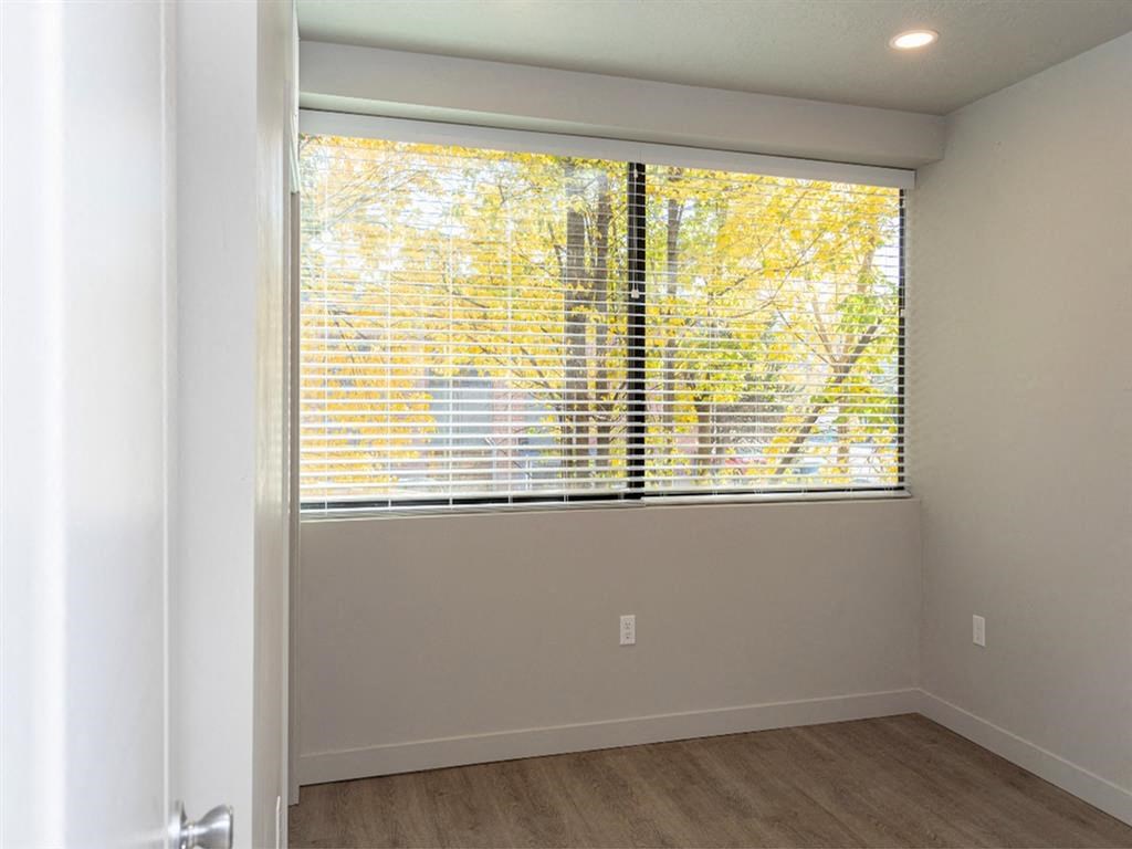 an empty room with a large window with blinds