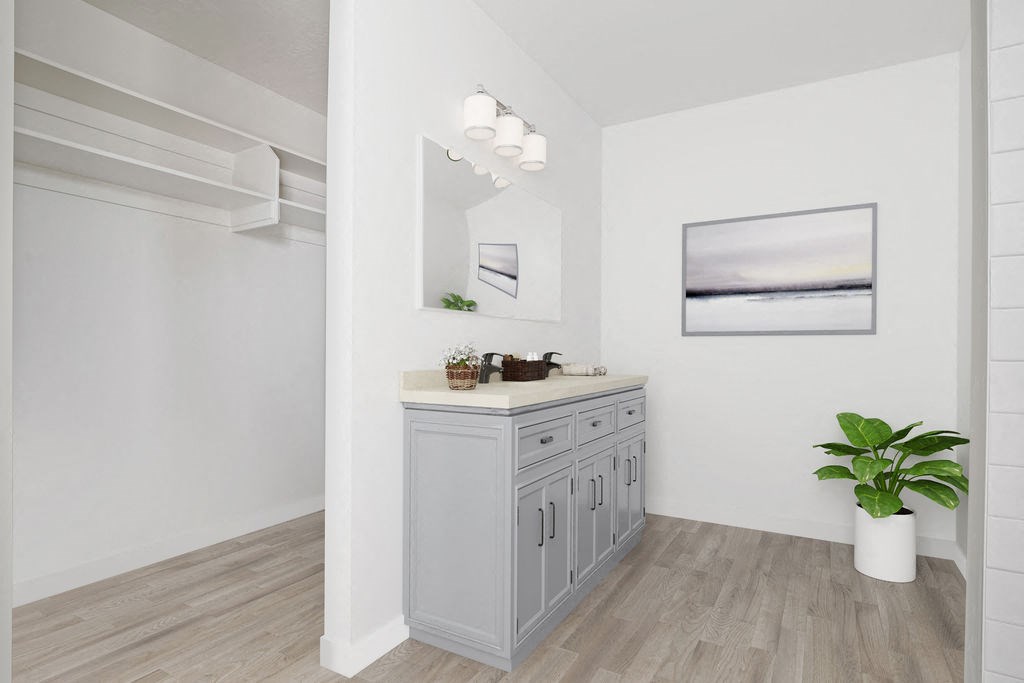 a white bathroom with a sink and a plant