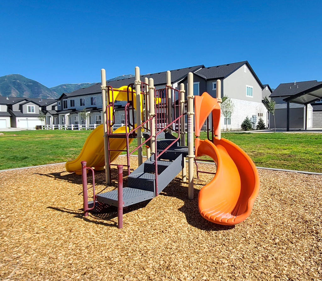 a playground with slides at the whispering winds apartments in pearland, tx
