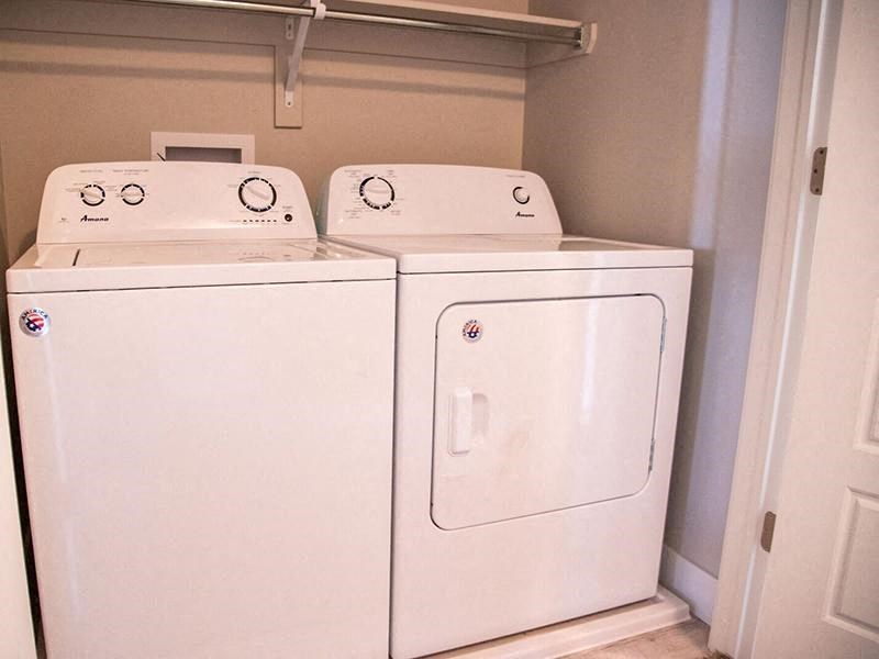 two washer and dryers in a room with a closet