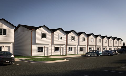 A row of houses with cars parked in front.