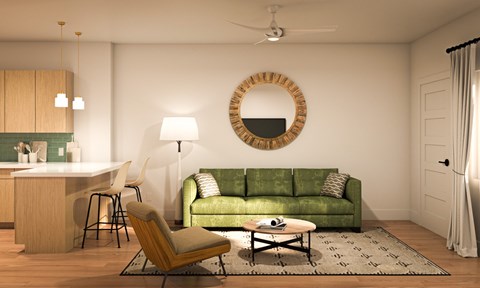 A living room with a green couch and a round mirror on the wall.