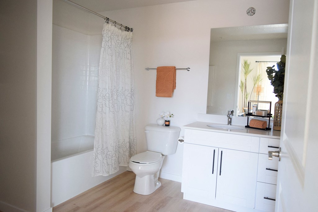 a bathroom with a white sink and toilet and a white shower curtain