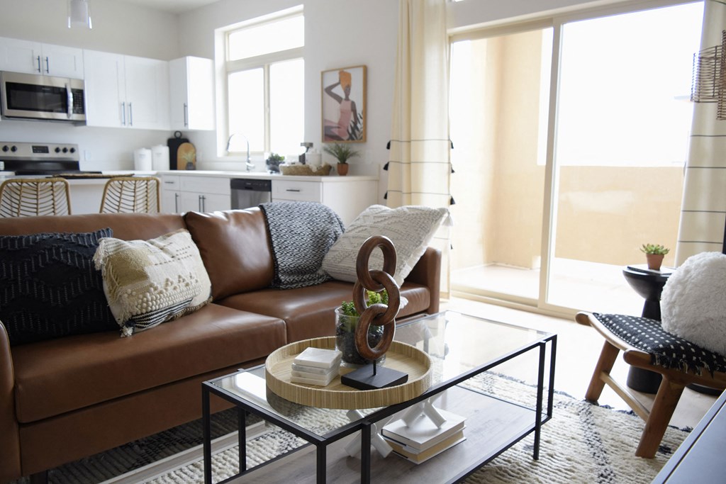 a living room with a brown couch and a coffee table with a sculpture on top of it