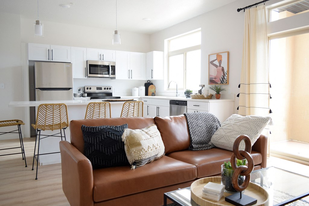 a living room with white walls and a brown leather couch