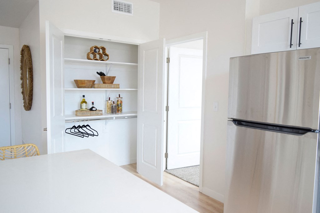 a kitchen with white walls and a stainless steel refrigerator