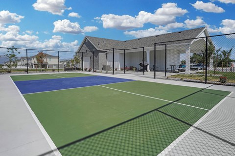 A tennis court with a building in the background.