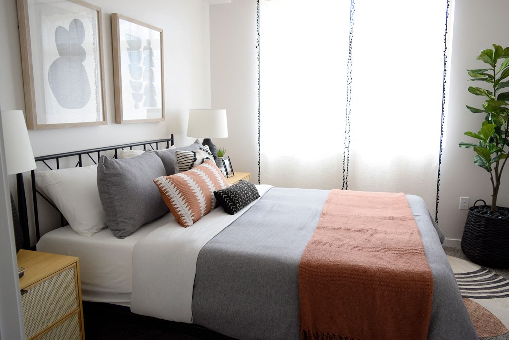 a bedroom with a bed and two paintings on the wall