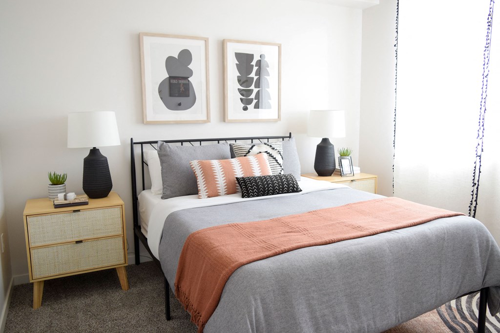 a bedroom with a bed and two night stands with lamps on them