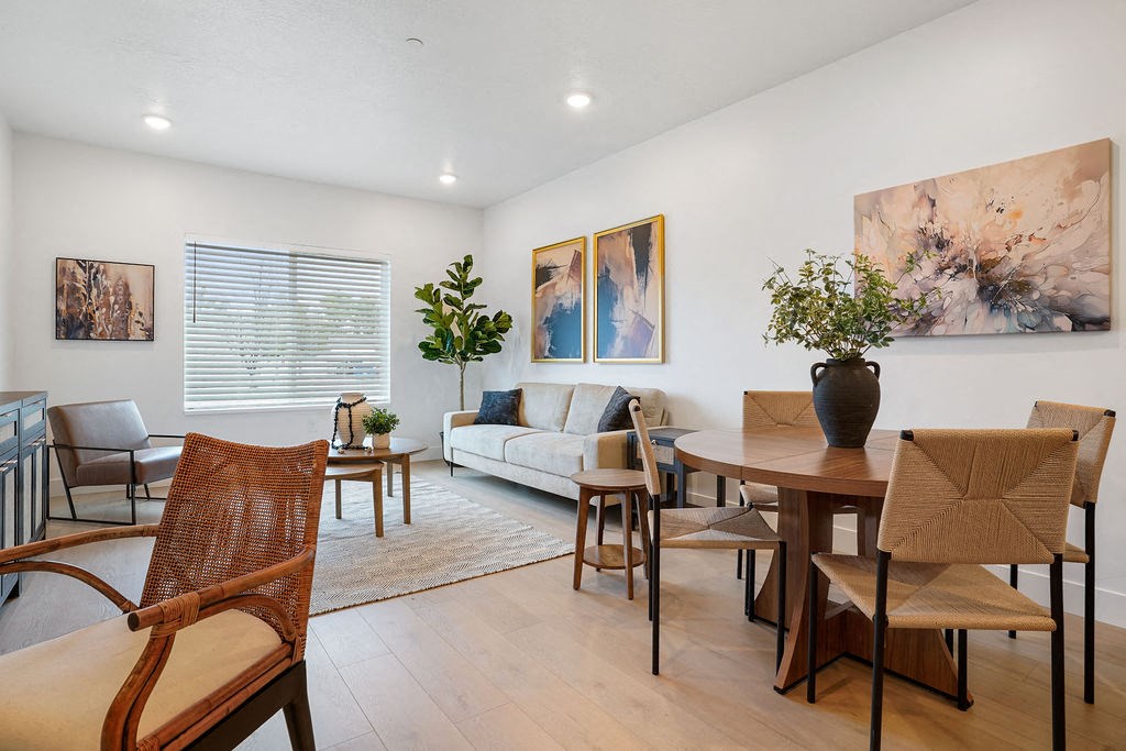 a living room and dining room with a table and chairs