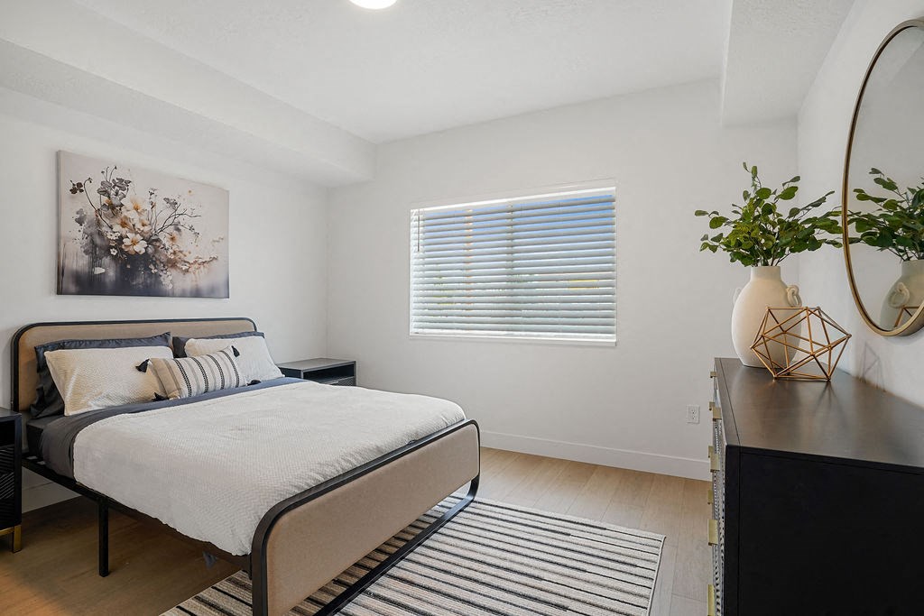 a bedroom with a bed and a dresser and a window