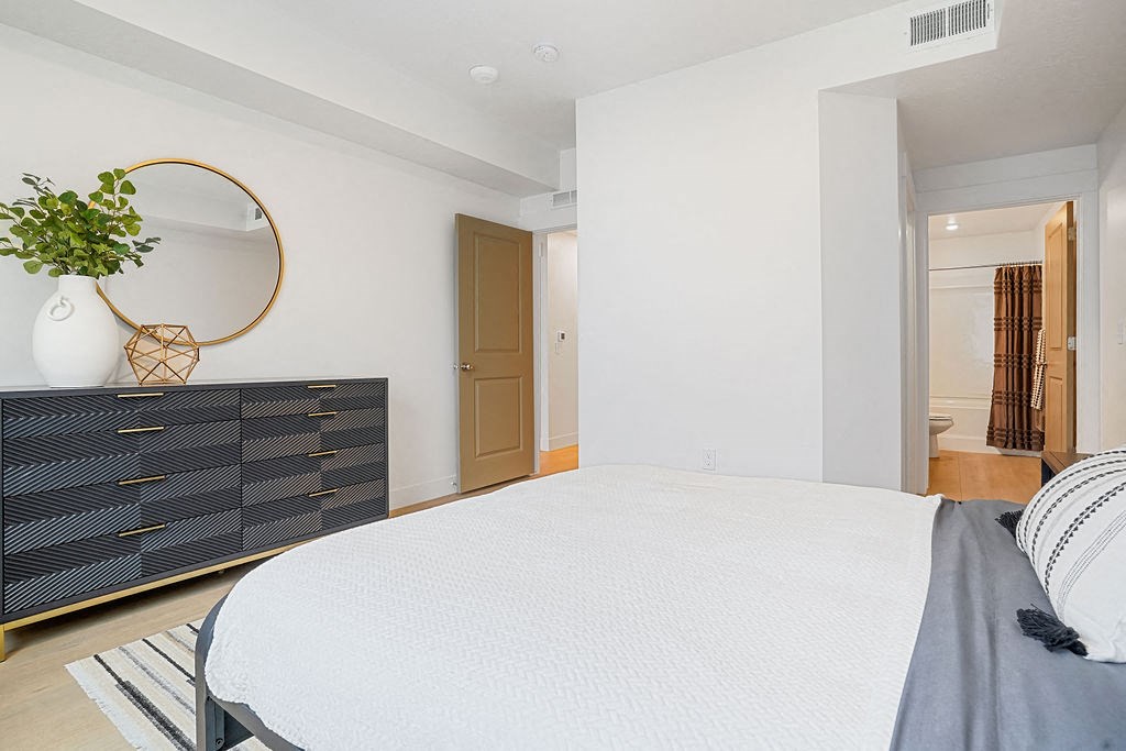 a bedroom with a large bed and a dresser