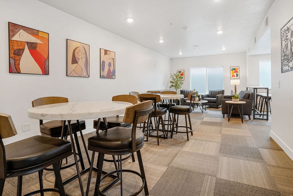 a dining room with tables and chairs and a living room with couches