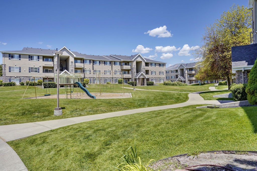 A large apartment complex with a playground in the front.