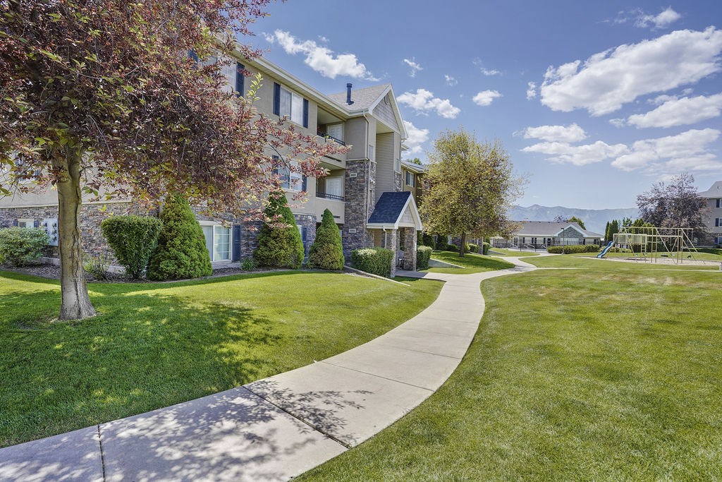 A residential area with apartment buildings and a well-maintained lawn.