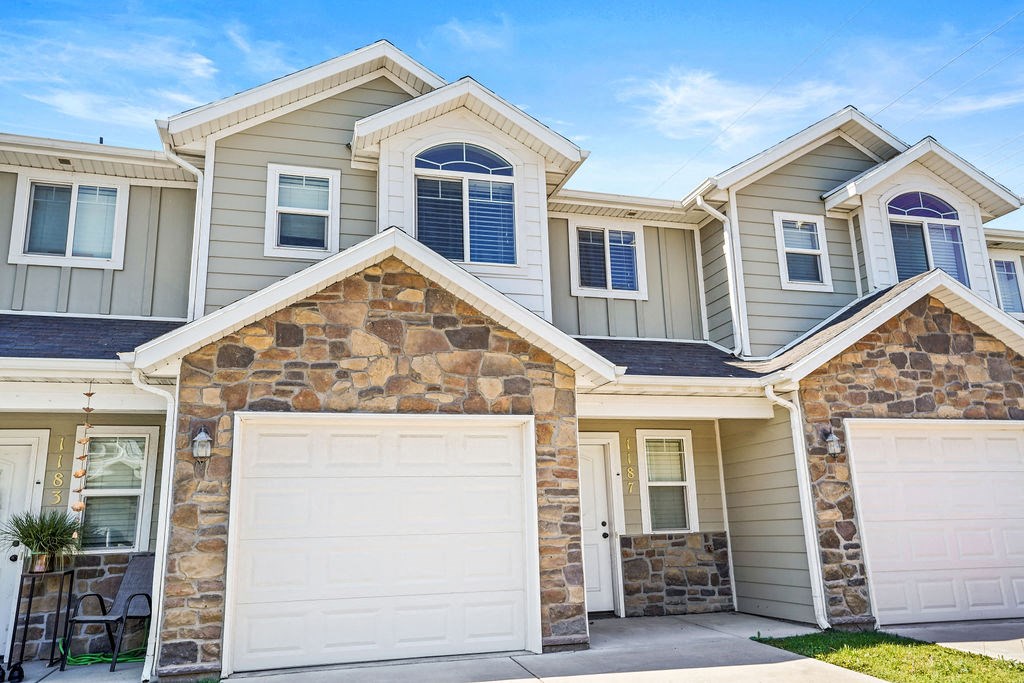 a beige house with two garage doors