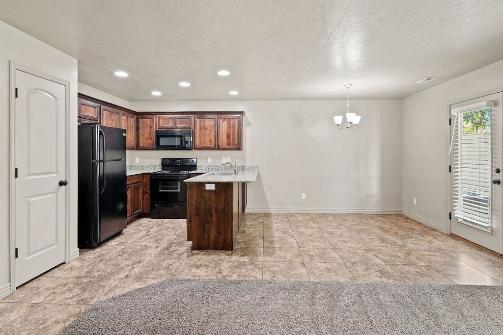 an empty kitchen with a refrigerator and a sink